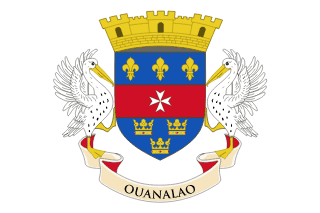 The flag of Saint Barthélemy features the national coat of arms centered on a white field. The coat of arms is a shield divided into three horizontal stripes: three gold fleurs-de-lis on blue, above a white Maltese cross on red, over three gold crowns on blue. Below the shield is a banner with "OUANALAO," which is what the indigenous people called the island. On top of the shield is a mural crown.