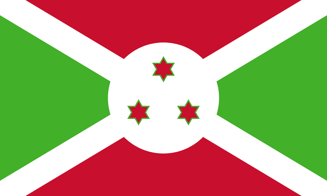 The flag of Burundi is divided by a white diagonal cross into four alternating triangular areas of red at the top and bottom, and green on the hoist and fly sides. A white circle, with three green-edged red six-pointed stars arranged to form a triangle, is superimposed at the center of the cross.