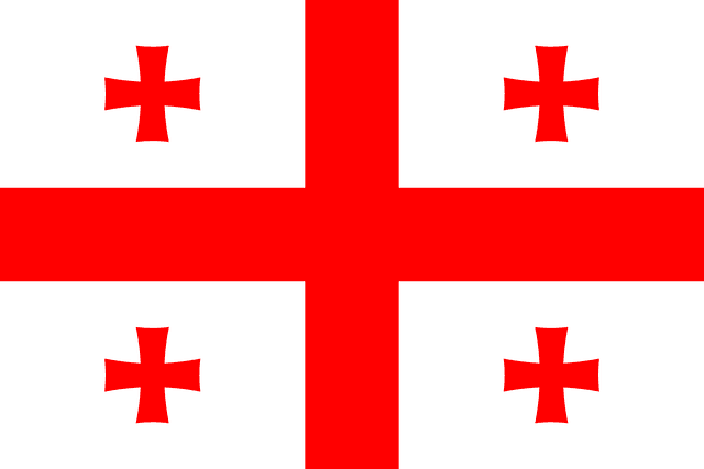 The flag of Georgia has a white field with a large centered red cross that extends to the edges and divides the field into four quarters. A small red Bolnur-Katskhuri cross is centered in each quarter.